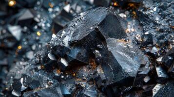 Detailed view of a mineral specimen featuring sharp, angular crystal formations with various shades of black and silver, illuminated by soft, natural light to reveal texture. photo