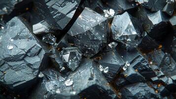 Dark mineral crystals are clustered together, their sharp edges reflecting light. Each facet reveals unique patterns and sparkling details, highlighting their natural beauty. photo