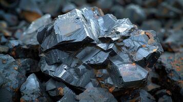 A striking black obsidian crystal stands out among surrounding stones, reflecting light and displaying its unique texture and angular shapes in a natural rocky setting. photo