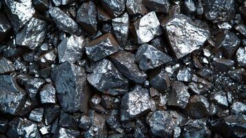 Close up view of shiny metallic mineral rocks scattered on the ground, showcasing their reflective surfaces and various shapes under natural daylight in a mining area. photo