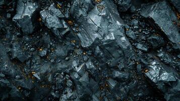 Textured gray rocks with shimmering golden veins are arranged closely together, creating a visually captivating contrast in a serene, naturally lit setting. photo