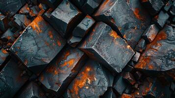 Rich in color and texture, the close up features bold orange and dark mineral blocks stacked intricately, revealing their unique crystalline structure illuminated by light. photo