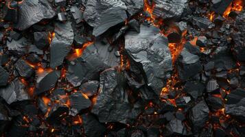 Dark, jagged lava rocks are illuminated by glowing orange embers, showcasing the intense heat and beauty of volcanic eruptions in a remote geological area. photo