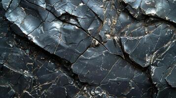 Close up view of dark volcanic rock with sharp edges and cracks, revealing intricate textures formed over time in a natural setting. photo