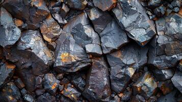 Detailed textures of dark rocks displaying a natural metallic shine and hints of rust, showcasing the geological features in a rugged terrain under bright daylight. photo