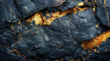 Textures of black slate rock reveal striking gold veins, creating a stunning contrast and intricate patterns that showcase nature's artistry in geological formations. photo