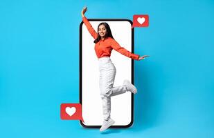 A person joyfully interacts with a smartphone displaying social media notifications, conveying themes of love and connection. The vibrant colors and heart symbols highlight Valentine's spirit. photo