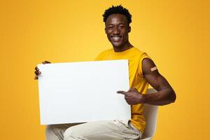 Young Happy Vaccinated Black Man Holding Blank Placard For Vaccination Advertisement, Millennial African American Guy With Plaster On Arm Showing Copy Space On White Poster, Beige Background, Mockup photo