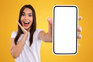Wow, Amazing Useful App. Portrait of excited and surprised young woman holding smartphone with black blank screen in hand, showing device, closeup. Gadget with empty free space for mock up template photo