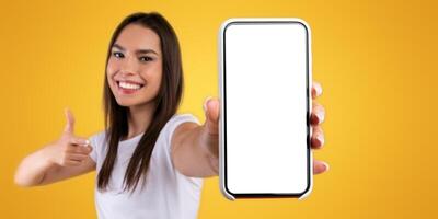 I Recommend. Portrait of smiling woman holding smartphone with white blank screen in hand, showing and pointing at device. Slective focus on gadget with empty free space for mock up, banner photo