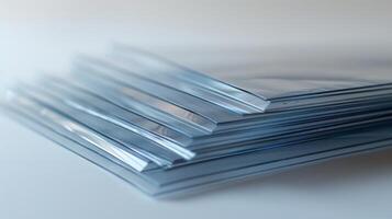 Assorted clear plastic sleeves are arranged in a neat stack on a light colored surface. Each sleeve offers a protective cover for documents or artwork, emphasizing an organized workspace. photo