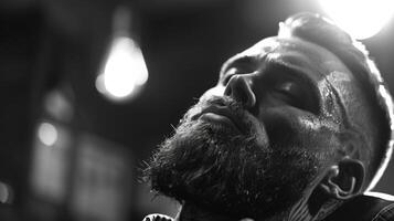 A man with a well groomed beard experiences a close shave. The warm lighting highlights his relaxed expression, creating a calm atmosphere. photo