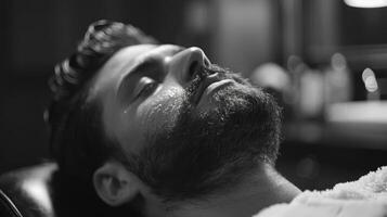 A man with a beard enjoys a grooming session in a barbershop, lying back in a chair while a barber works on his facial hair, creating a calming atmosphere. photo