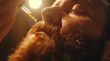 Man gently applies beard oil using a dropper, focusing on personal grooming and self care in a cozy atmosphere during the evening hours, with warm lighting enhancing the scene. photo