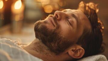 A man with a beard rests peacefully with his eyes closed, savoring a tranquil moment surrounded by soft ambient light and gentle warmth, conveying relaxation and comfort. photo