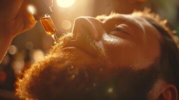 A man focuses on applying beard oil to his facial hair in a softly lit environment, highlighting personal grooming and self care during the evening hours at home. photo