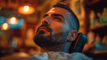 A man with a well groomed beard lies back in a barbershop chair, enjoying a grooming session while warm light creates an inviting atmosphere in the shop. photo