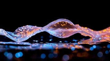 A flowing wave of light with sparkling elements against a dark background. photo