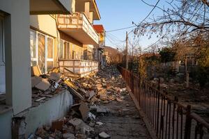 Debris-strewn street beside damaged buildings in a desolate area. photo