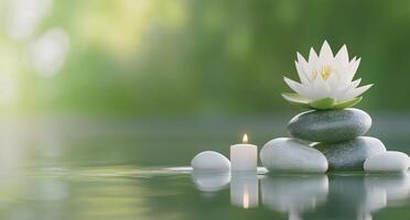 A serene scene featuring a lotus flower, candles, and stones on water. photo