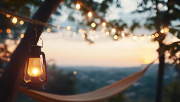 A cozy outdoor scene with a lantern and string lights at sunset. photo