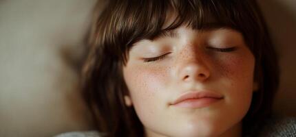 A serene close-up of a young person resting peacefully with closed eyes. photo