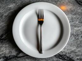 Elegant Minimalist Dining Concept with Fork on White Plate on Marble Table photo