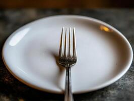 Minimalist Close-Up of a Fork on a White Plate with Blurred Background photo