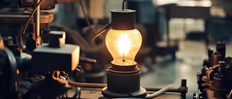 Global Economic Crisis Oil Concept. A vintage lamp illuminates a dim industrial setting, highlighting the intricate machinery around it and creating a warm ambiance. photo
