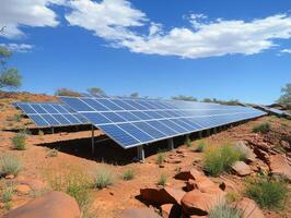 Solar panels installed on rugged terrain under a clear blue sky, showcasing renewable energy technology in a natural landscape. photo