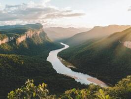 Lush green mountains with a winding river under a golden sunset sky, showcasing natural beauty and tranquility. photo