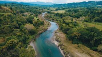 A serene river winds through lush greenery, surrounded by rolling hills and a tranquil landscape, capturing the beauty of nature. photo