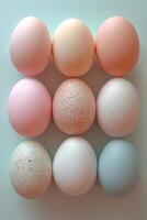 Nine colorful easter eggs forming a square on a light blue background photo
