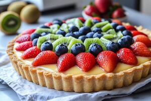 Delicious fruit tart with pastry cream, kiwi, blueberries and strawberries resting on a table photo