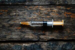 Syringe with needle resting on aged wooden planks photo