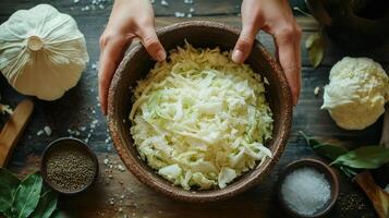 Chef holding bowl of freshly cut cabbage with ingredients surrounding it photo
