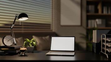 A modern office features a laptop with a white screen mockup and decorative items on a black desk. photo