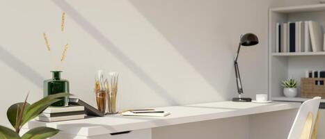 A white desk with painting tools, books, and decorative items, set in a minimalist white room. photo