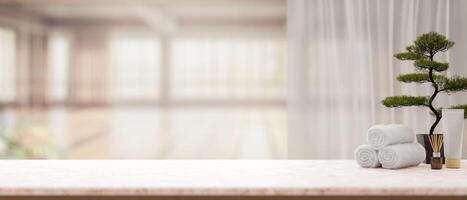 the white marble table with spa essentials and bonsai pot with blurry background of bright room. photo