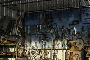 A tool hanging board with various equipment, looks old and has been used for a long time. photo