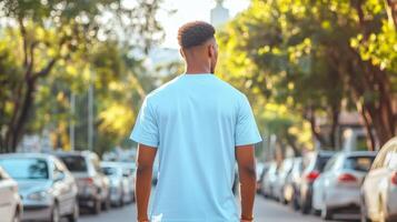 Man in light blue shirt walking down a street photo
