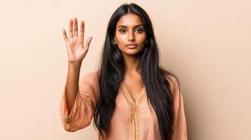 Young Woman Showing Five Fingers Up Against Beige Background photo