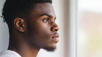 Young Man Contemplating Near a Window photo
