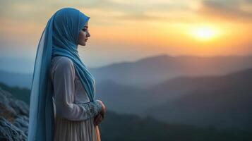 Woman In Hijab Gazes At Sunset Over Mountains photo