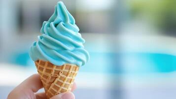 A Hand Holds A Light Blue Soft Serve Ice Cream Cone photo