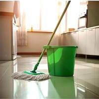 mop and green bucket on a clean shiny floor in a well-lit kitchen environment photo