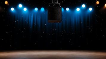 A spotlighted microphone hanging over an empty stage with colorful lights and a dark curtain backdrop photo
