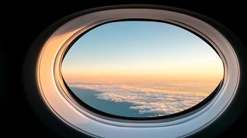A serene view from an airplane window showcasing a colorful sunrise over the clouds photo