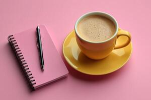 coffee cup saucer sits next small notebook and pen all arranged on pastel pink background. setup creates inviting workspace ideal for creative tasks or note taking photo