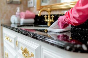 person in pink gloves cleans mirror microfiber cloth while reflections of well organized room enhance tidy atmosphere. cleanliness shows attention detail photo
